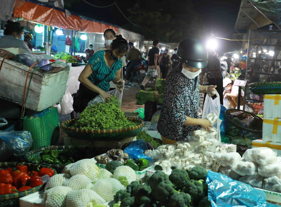 Người dân lựa chọn mua rau củ tại chợ đầu mối Minh Khai. (Ảnh: Vũ Sinh/TTXVN)