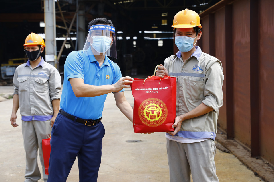 Phó Chủ tịch Liên đoàn Lao động thành phố Hà Nội Lê Đình Hùng trao quà cho công nhân lao động Công ty TNHH Bê tông Bình Dương. (Ảnh: Minh Đức/TTXVN)