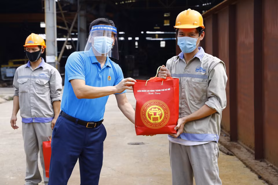 Phó Chủ tịch Liên đoàn Lao động thành phố Hà Nội Lê Đình Hùng trao quà cho công nhân lao động Công ty TNHH Bê tông Bình Dương. (Ảnh: Minh Đức/TTXVN)