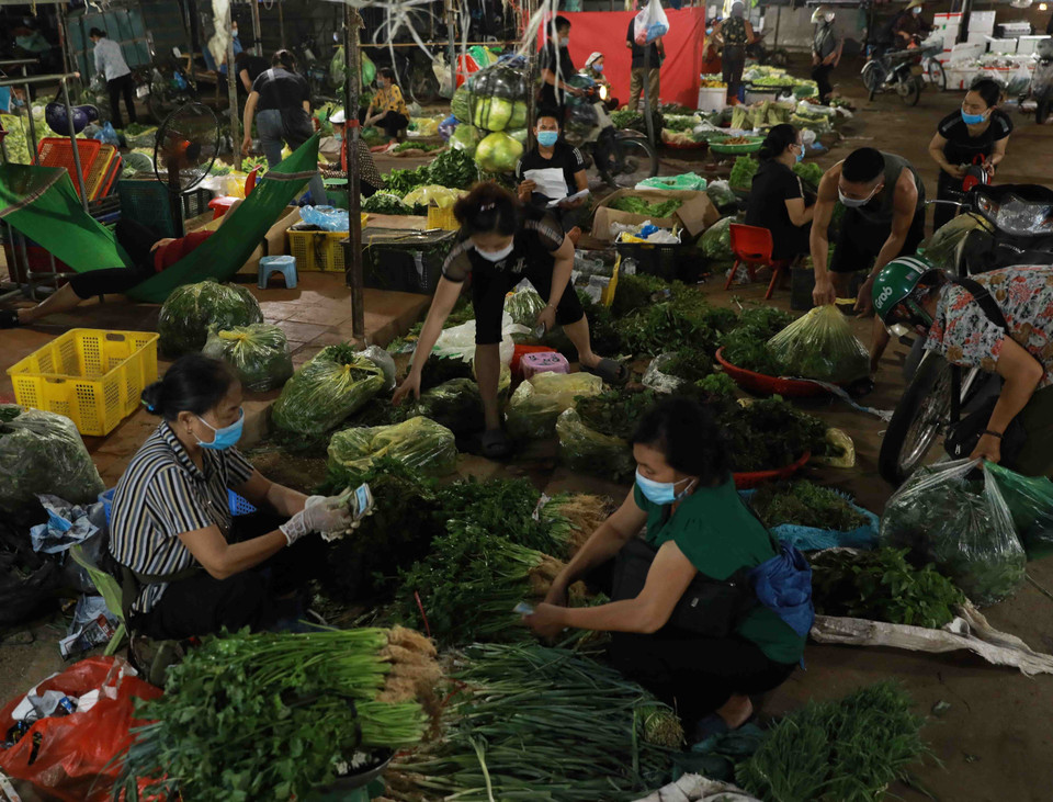 Hoạt động mua bán tại chợ đầu mối Minh Khai. (Ảnh: Vũ Sinh/TTXVN)