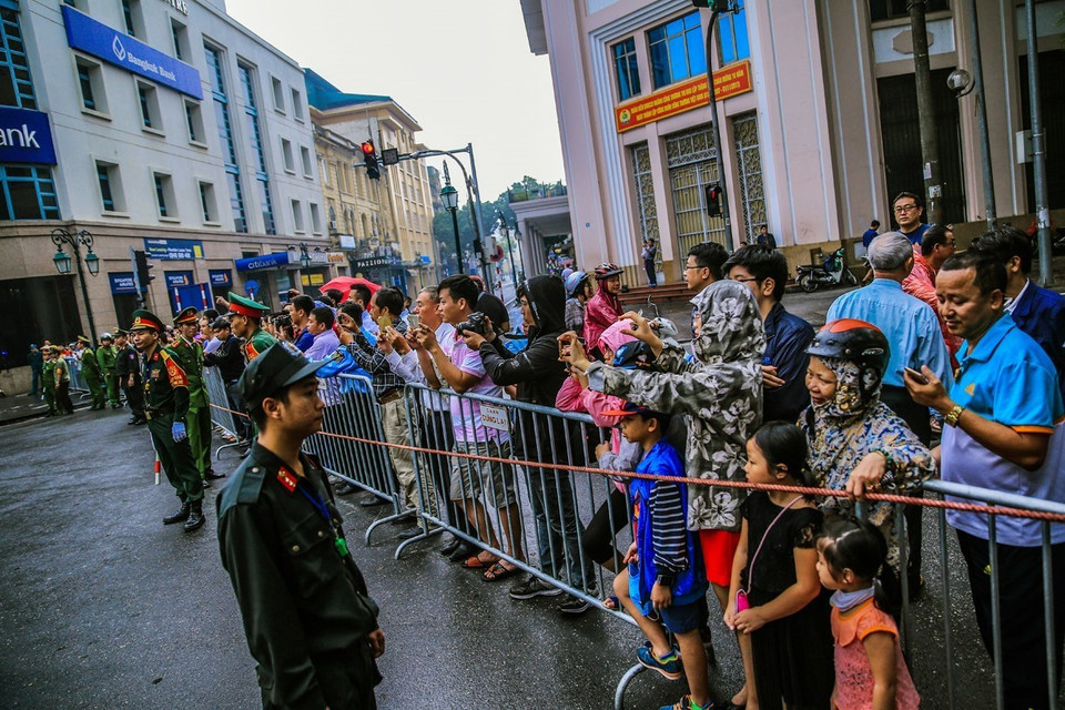 Người dân đứng bên đường nơi đoàn xe chở Tổng thống Hoa Kỳ Donald Trump sẽ di chuyển qua. (Ảnh: Trọng Đạt/TTXVN)