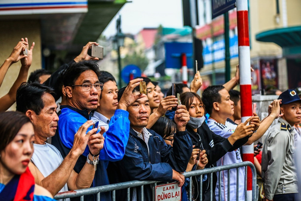 Người dân đứng bên đường nơi đoàn xe chở Tổng thống Hoa Kỳ Donald Trump sẽ di chuyển qua. (Ảnh: Trọng Đạt/TTXVN)