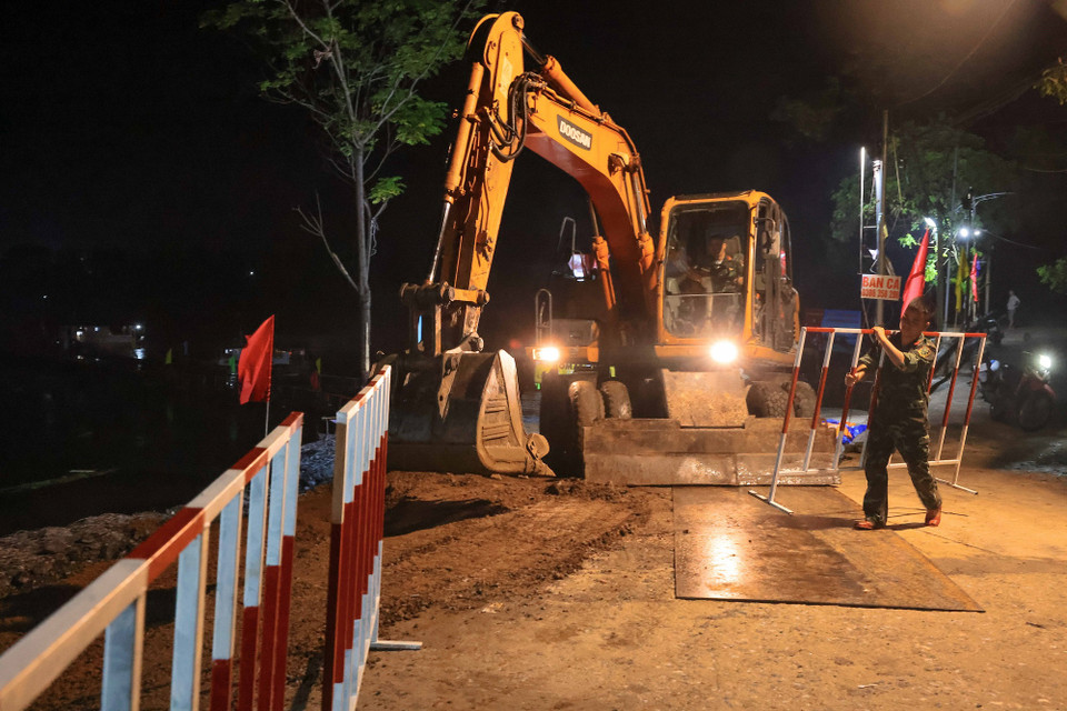 Lực lượng công binh Lữ đoàn 249 tiến hành san lấp, gia cố nơi mặt nền yếu, tạo hành lang đảm bảo an toàn cho người và phương tiện lưu thông (ảnh chụp lúc 5h ngày 30/9). (Ảnh: Hoàng Hiếu/TTXVN)