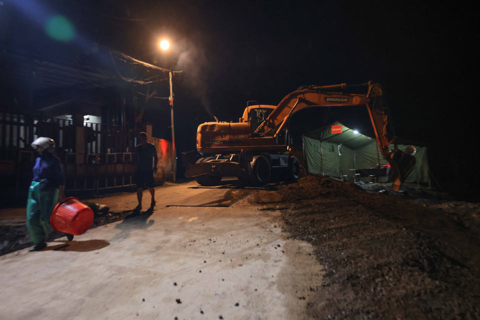 Lực lượng công binh Lữ đoàn 249 tiến hành san lấp, gia cố nơi mặt nền yếu, đảm bảo an toàn cho người và phương tiện lưu thông (ảnh chụp lúc 5h ngày 30/9). (Ảnh: Hoàng Hiếu/TTXVN)