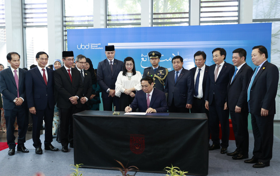 Thủ tướng Phạm Minh Chính ký lưu niệm khi đến thăm trường đại học Quốc gia Brunei. (Ảnh: Dương Giang/TTXVN)