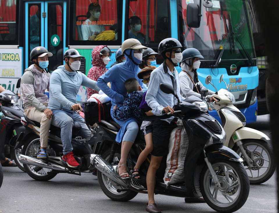Trẻ nhỏ đi cùng bố mẹ trên các phương tiện với nhiều đồ đạc lỉnh kỉnh, di chuyển từ hướng phía Nam để vào trung tâm Hà Nội. (Ảnh: Hoàng Hiếu/TTXVN)