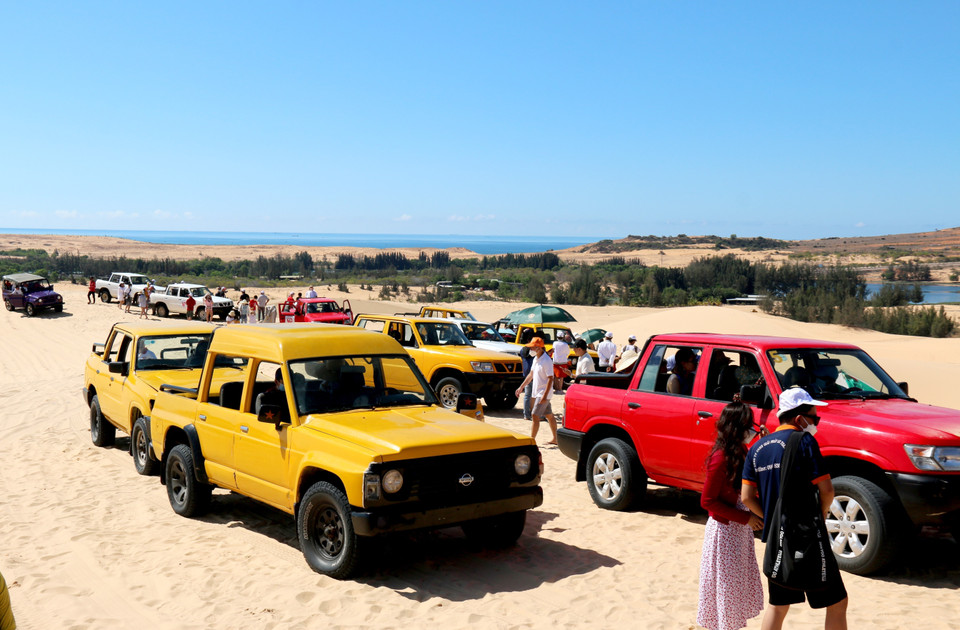 Du khách dùng xe địa hình di chuyển lên điểm cao nhất của đồi cát Bàu Trắng. (Ảnh: Nguyễn Thanh/TTXVN)