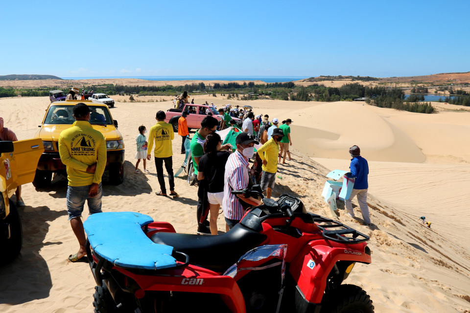 Du khách dùng xe địa hình di chuyển lên điểm cao nhất của đồi cát Bàu Trắng. (Ảnh: Nguyễn Thanh/TTXVN)