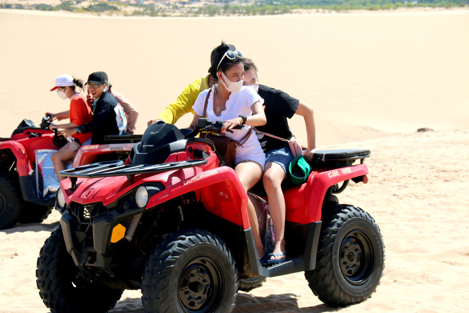 Du khách trải nghiệm đi xe địa hình tại Bàu Trắng. (Ảnh: Nguyễn Thanh/TTXVN)