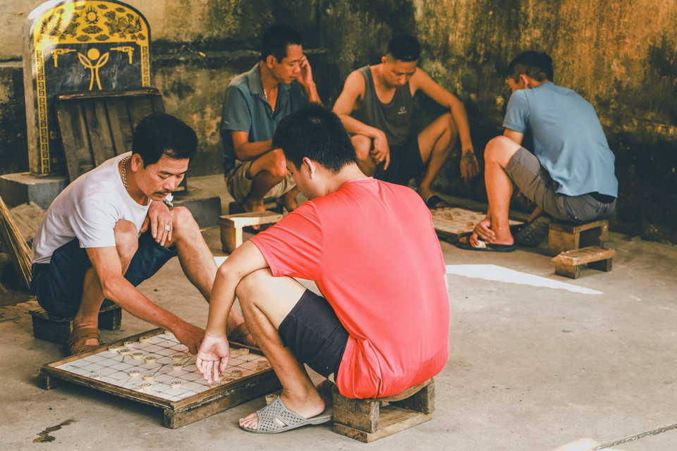 Những người dân làng tụ tập chơi cờ tướng, một hoạt động văn hóa truyền thống của cộng đồng nơi đây. (Ảnh: Vân Chi/TTXVN phát)