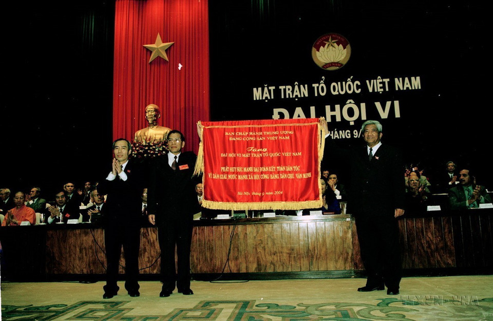 Tổng Bí thư Nông Đức Mạnh tặng bức trướng cho Ủy Ban Trung ương Mặt trận Tổ quốc Việt Nam tại Lễ khai mạc Đại hội đại biểu toàn quốc Mặt trận tổ quốc Việt Nam lần thứ VI (22/9/2004). (Ảnh: Thế Thuần/TTXVN)