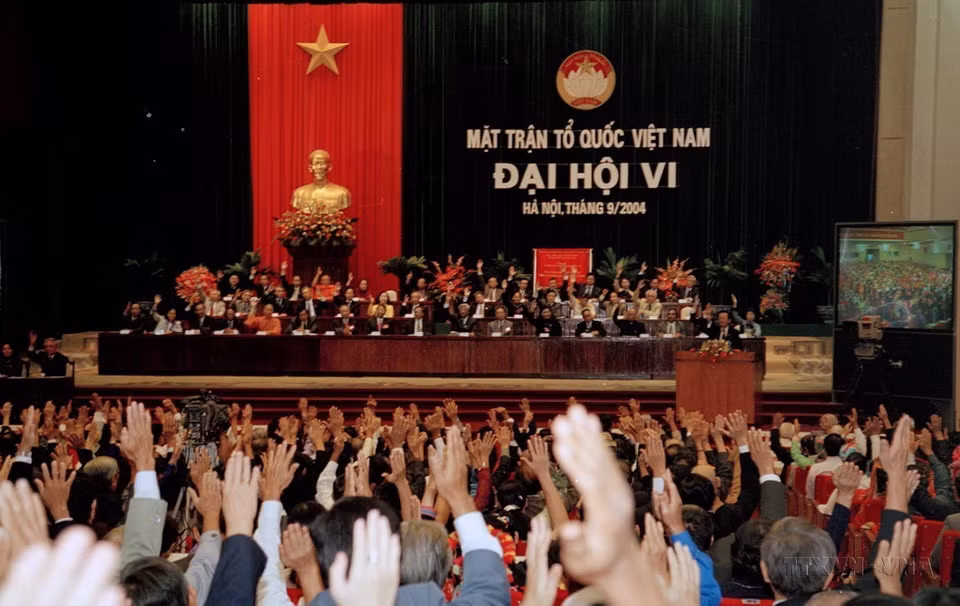 Các đại biểu biểu quyết thông qua Nghị quyết Đại hội đại biểu Mặt trận tổ quốc Việt Nam lần thứ VI (2004). (Ảnh: Nhan Sáng/TTXVN)