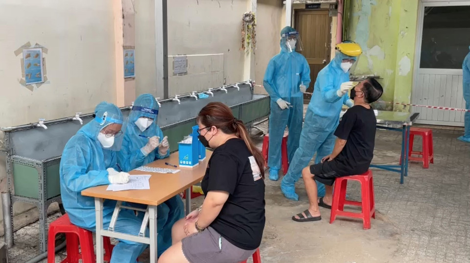 Cán bộ y tế của Trung tâm y tế quận 1 lấy mẫu xét nghiệm tầm soát cho người dân khu vực Mả Lạng, Phường Nguyễn Cư Trinh, quận 1. (Ảnh: Đinh Hằng/TTXVN)