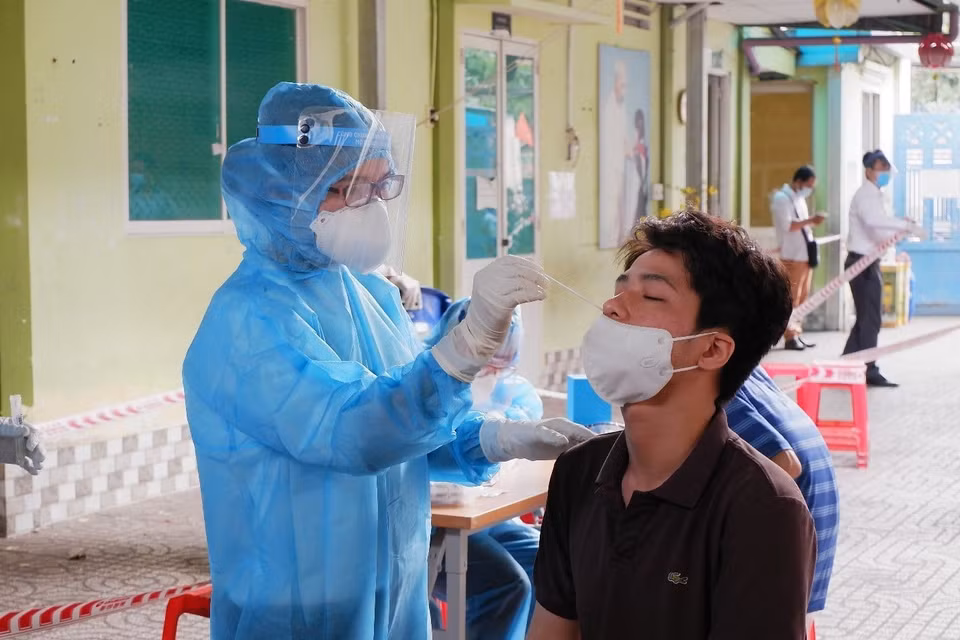 Cán bộ y tế của Trung tâm y tế Quận 1 lấy mẫu xét nghiệm tầm soát cho người dân khu vực Mả Lạng, Phường Nguyễn Cư Trinh, quận 1. (Ảnh: Đinh Hằng/TTXVN)