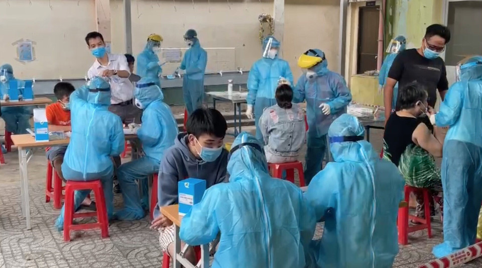 Cán bộ y tế của Trung tâm y tế quận 1 lấy mẫu xét nghiệm tầm soát cho người dân khu vực Mả Lạng, Phường Nguyễn Cư Trinh,Quận 1. (Ảnh: Đinh Hằng/TTXVN)