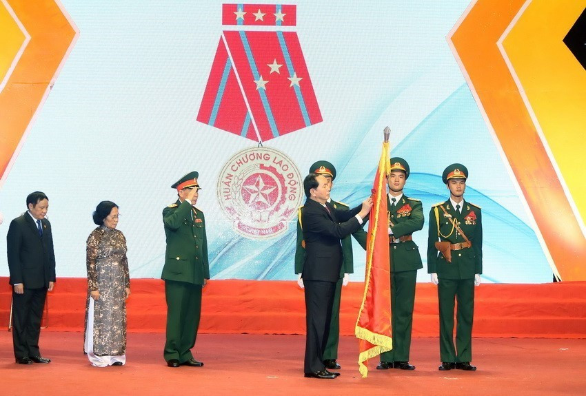 Chủ tịch nước Trần Đại Quang gắn Huân chương Lao động hạng Nhất lên lá cờ truyền thống của Hội Nạn nhân chất độc da cam/dioxin Việt Nam, tại Lễ míttinh kỷ niệm 55 năm Thảm họa da cam ở Việt Nam (10/8/1961-10/8/2016). (Ảnh: Nhan Sáng/TTXVN)