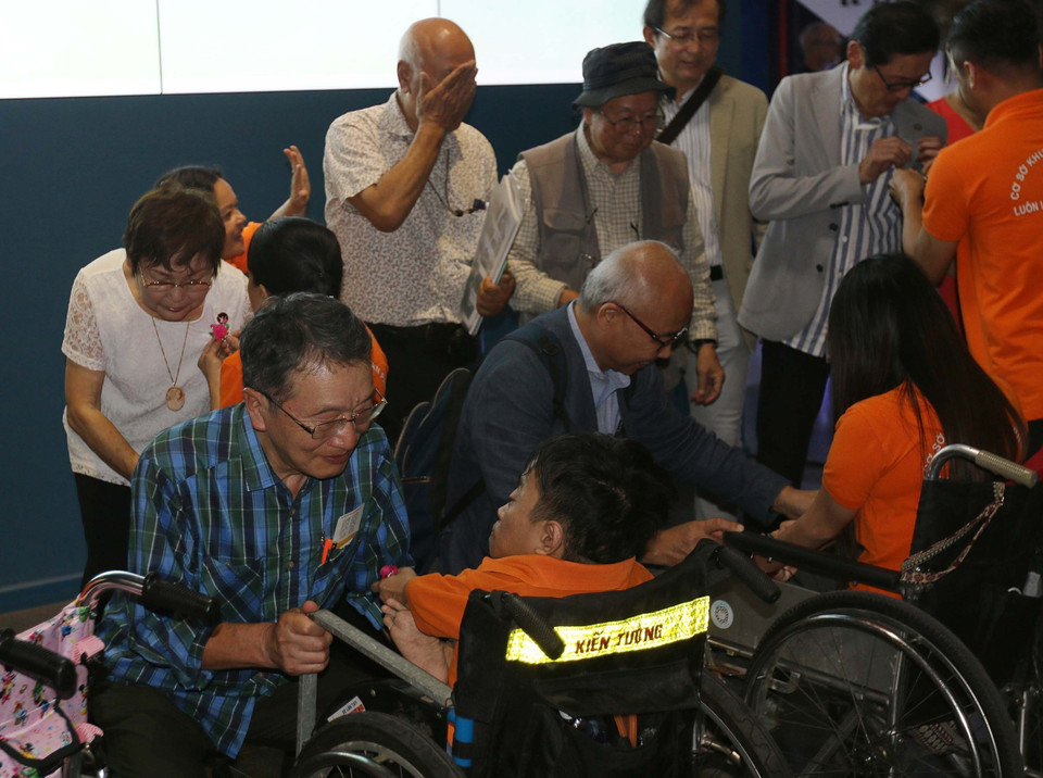 Các em Làng Hòa Bình, nạn nhân chất độc da cam/dioxin tặng quà lưu niệm các đại biểu Nhật Ban tham dự Triển lãm Ảnh về nạn nhân chiến tranh tại Nhật Bản và Việt Nam. ( Ảnh: Thanh Vũ/TTXVN)