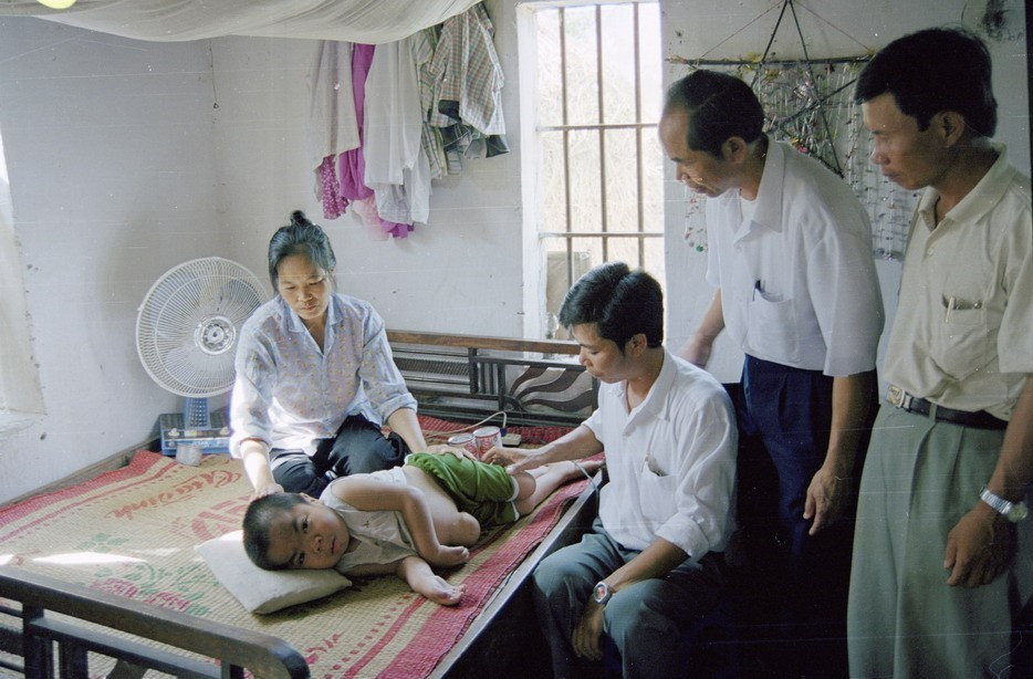 Cán bộ xã Hải Thanh, huyện Hải Hậu, tỉnh Nam Định đến thăm, tặng quà cho cháu Lê Xuân Diệu (sinh năm 1990), con anh Lê Xuân Đường, bộ đội chiến đấu ở chiến trường miền Nam, bị dị dạng do nhiễm chất độc da cam/dioxin (1998). (Ảnh: Vũ Hanh/TTXVN)