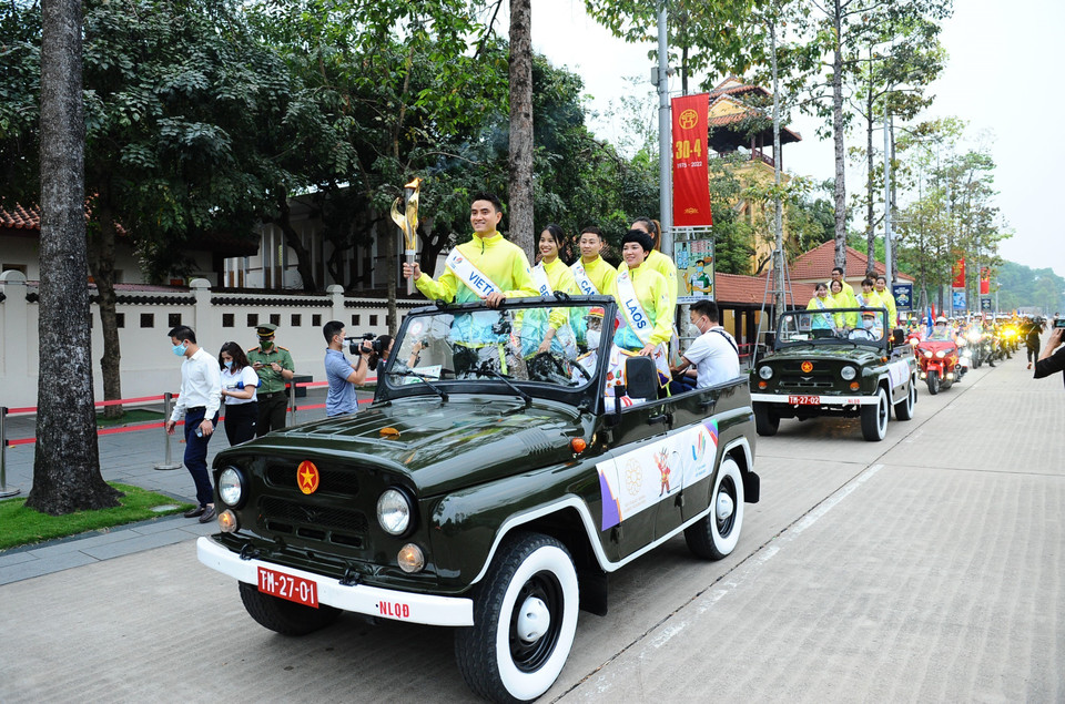Lễ diễu hành xin lửa với 2 ôtô mui trần chở 11 vận động viên tiêu biểu tượng trưng cho 11 nước tham dự SEA Games 31 đứng trên xe, trong đó có 1 vận động viên cầm đuốc chưa thắp lửa, 31 xe môtô phân khối lớn (tượng trưng cho SEA Games 31) có gắn cờ các nước, cờ SEA Games 31, cờ Liên đoàn Thể thao Đông Nam Á. (Ảnh: Minh Đức/TTXVN)