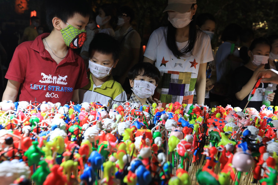 Người lớn, trẻ em đều thích thú với các sản phẩm của làng nghề tò he truyền thống làng Xuân La, xã Phượng Dực (Phú Xuyên, Hà Nội). (Ảnh: Hoàng Hiếu/TTXVN)