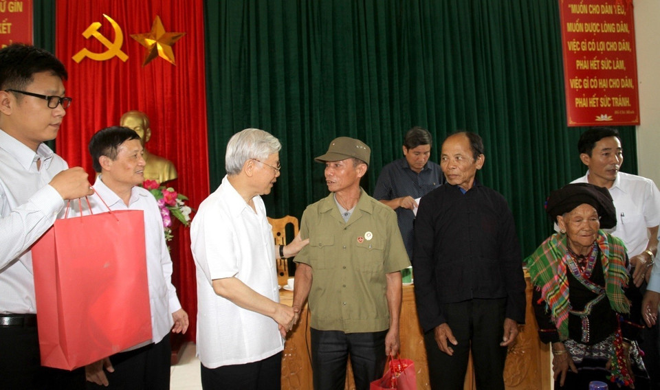 Tổng Bí thư Nguyễn Phú Trọng trò chuyện, động viên thương binh Nguyễn Văn Dũng xã Bản Bo, huyện Tam Đường vào tháng 7/2016. (Ảnh: TTXVN phát)