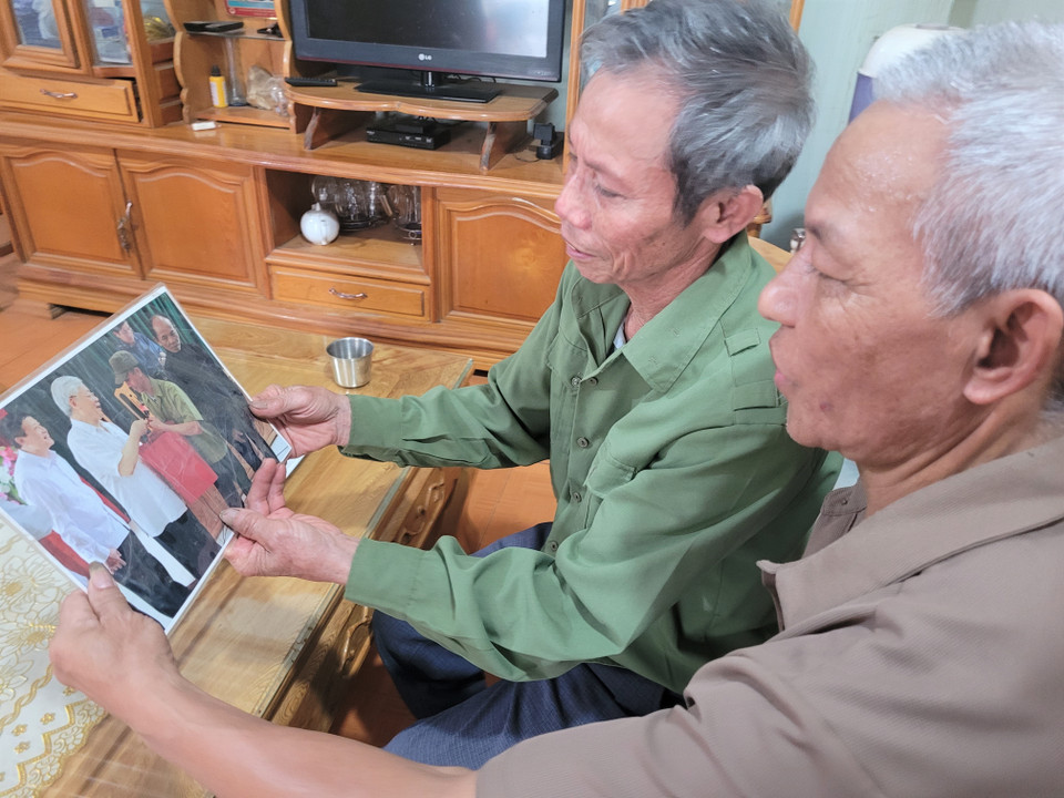 Thương binh Nguyễn Văn Dũng (áo xanh) ở bản Hưng Phong, xã Bản Bo, huyện Tam Đường (Lai Châu) cầm bức ảnh được chụp với Tổng Bí thư Nguyễn Phú Trọng. (Ảnh: Nguyễn Oanh/TTXVN)