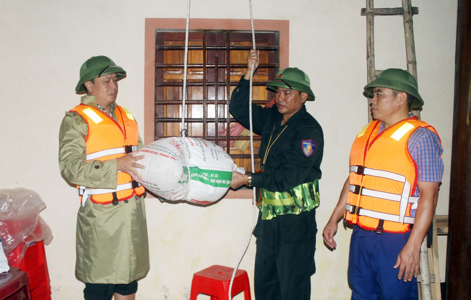 Chính quyền địa phương hỗ trợ đảm bảo lương thực cho người dân vùng ngập. (Ảnh: Tá Chuyên/TTXVN)