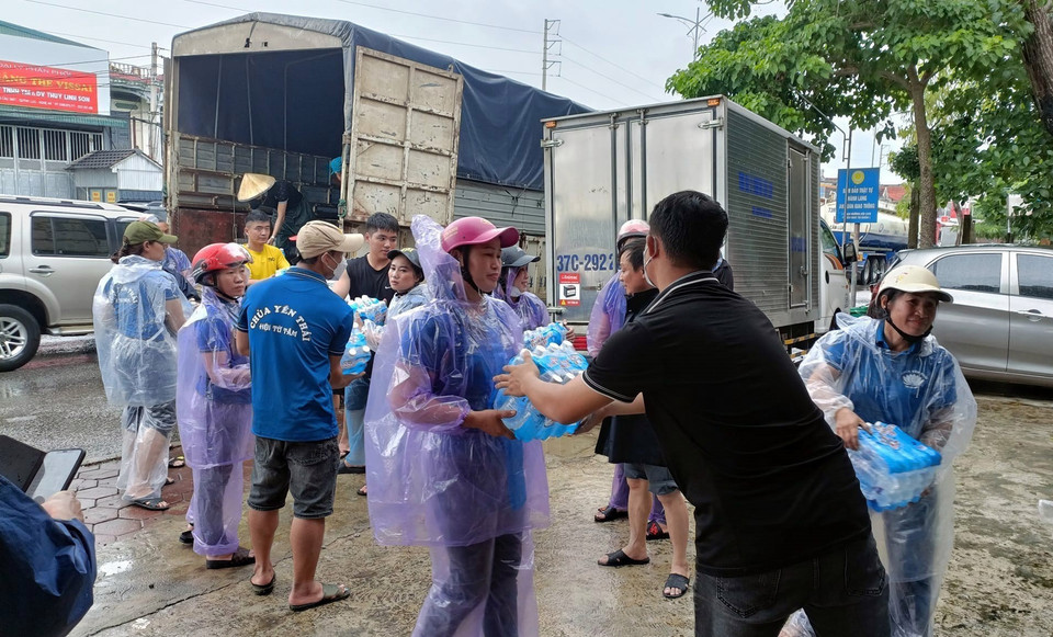 Lực lượng chức năng vận chuyển nước uống hỗ trợ người dân vùng bị ngập tại huyện Quỳnh Lưu (Nghệ An). (Ảnh: Tá Chuyên/TTXVN)
