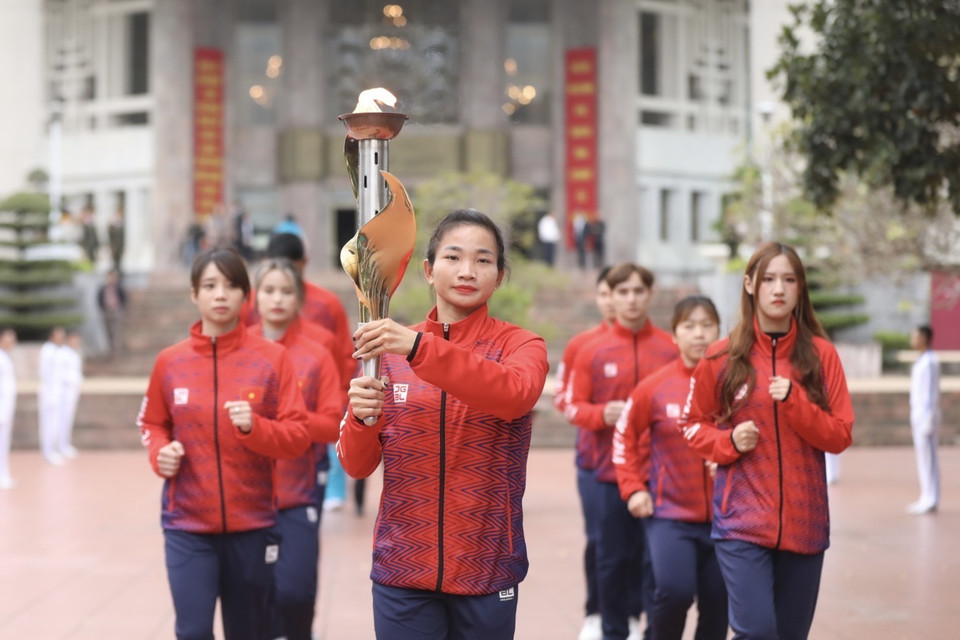 Đoàn vận động viên tiêu biểu thực hiện nghi thức rước đuốc từ Bảo tàng Hồ Chí Minh. (Ảnh: Minh Quyết/TTXVN)