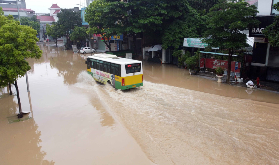Chỉ có những xe gầm cao mới có thể vượt qua những đoạn đường ngập sâu trong nước trên đường Tôn Đức Thắng, thành phố Vĩnh Yên. (Ảnh: Hoàng Hùng/TTXVN)