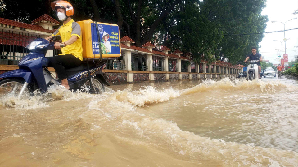 Người dân vất vả di chuyển trên đường Mê Linh, thành phố Vĩnh Yên. (Ảnh: Hoàng Hùng/TTXVN)