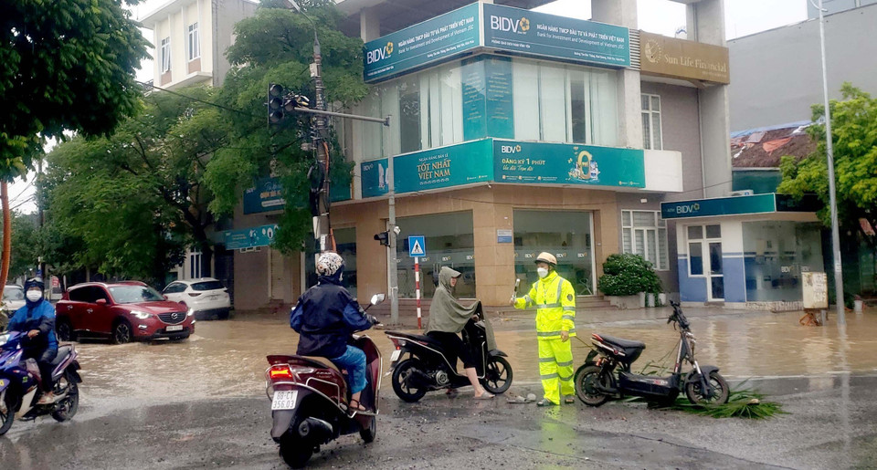 Người dân lúng túng tìm cách di chuyển qua những tuyến đường bị ngập nước tại thành phố Vĩnh Yên. (Ảnh: Hoàng Hùng/TTXVN)