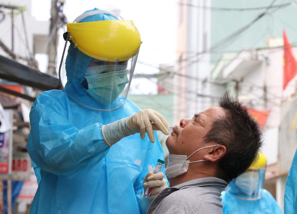 Cán bộ y tế lấy mẫu xét nghiệm cho các công dân trên đường Nguyễn Duy Hiệu, quận Sơn Trà, thành phố Đà Nẵng. (Ảnh: Quốc Dũng/TTXVN)