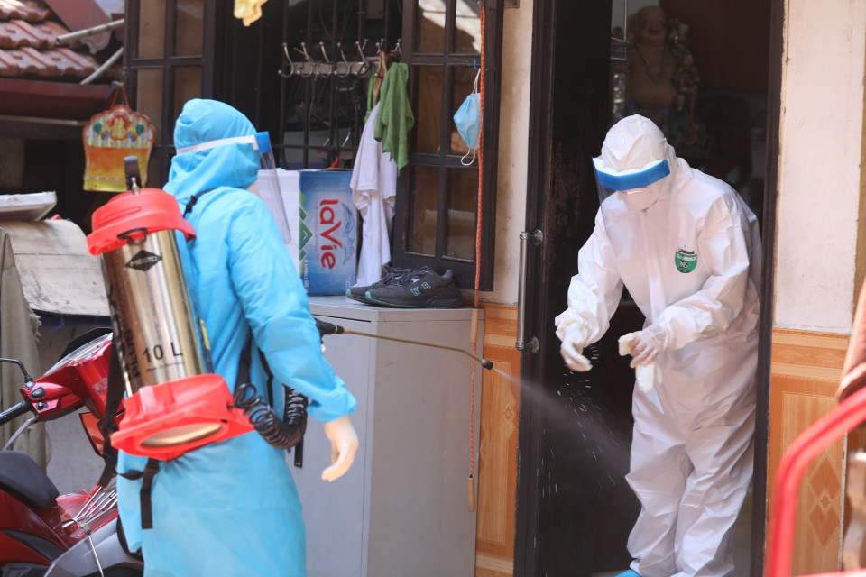 Nhân viên y tế được khử khuẩn sau khi lấy mẫu xong (ảnh chụp 31/5/2021). (Ảnh: Minh Quyết/TTXVN)