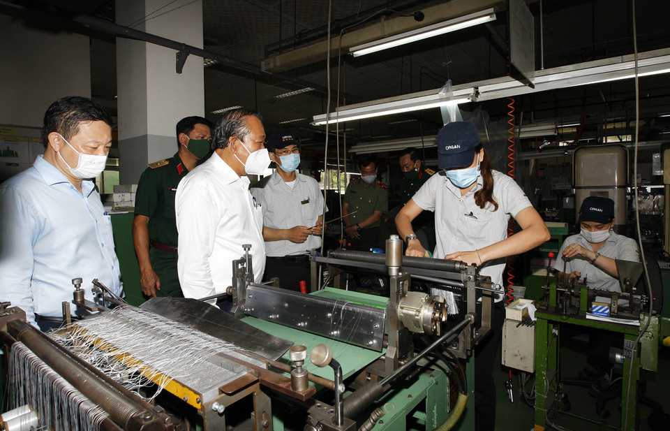 Phó Thủ tướng thường trực Chính phủ Trương Hòa Bình kiểm tra phòng, chống dịch bệnh tại Công ty trách nhiệm hữu hạn Kim may Organ. (Ảnh: Thanh Vũ/TTXVN)