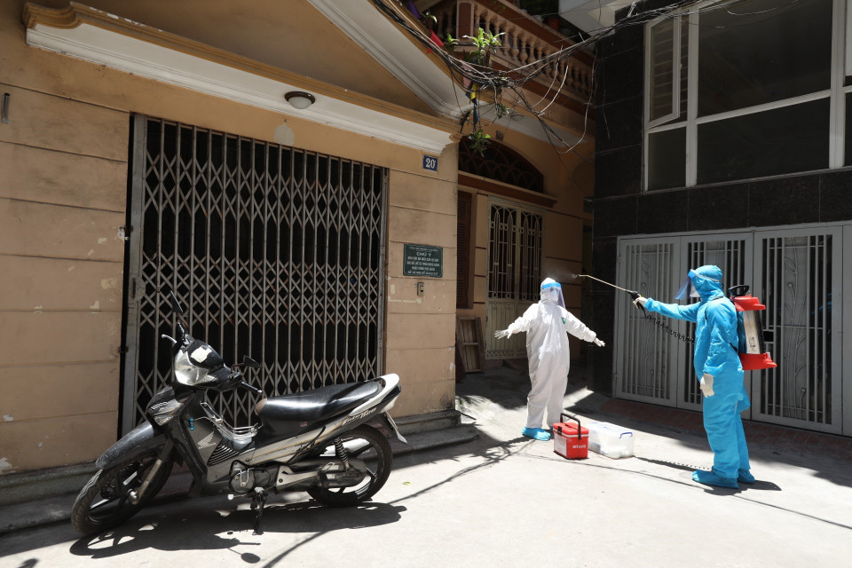 Nhân viên y tế được khử khuẩn sau khi lấy mẫu xong (ảnh chụp 31/5/2021). (Ảnh: Minh Quyết/TTXVN)