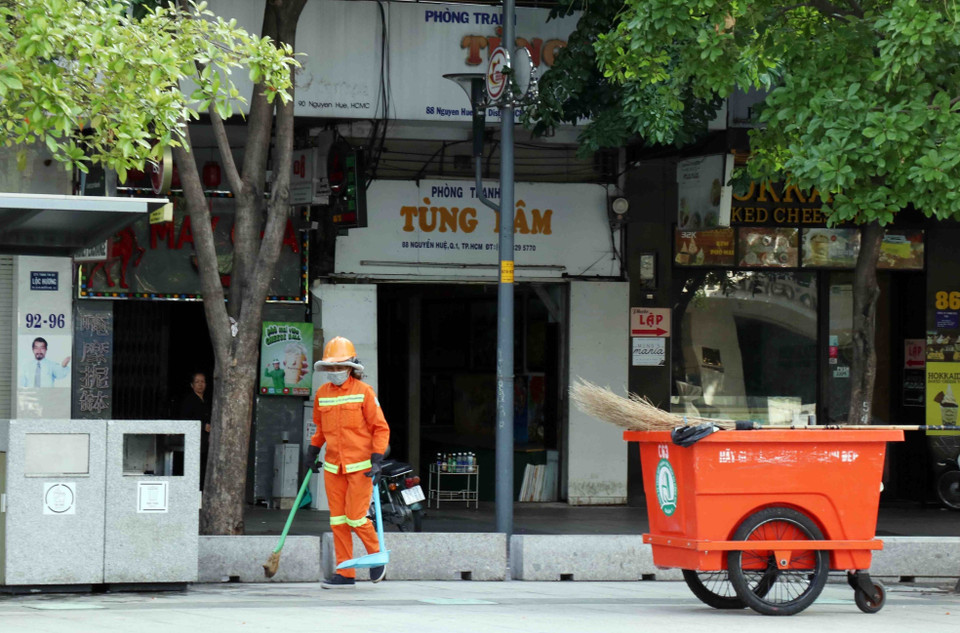 Lực lượng công ích vẫn hoạt động tại khu vực phố đi bộ Nguyễn Huệ (Quận 1). (Ảnh: Xuân Khu/TTXVN)