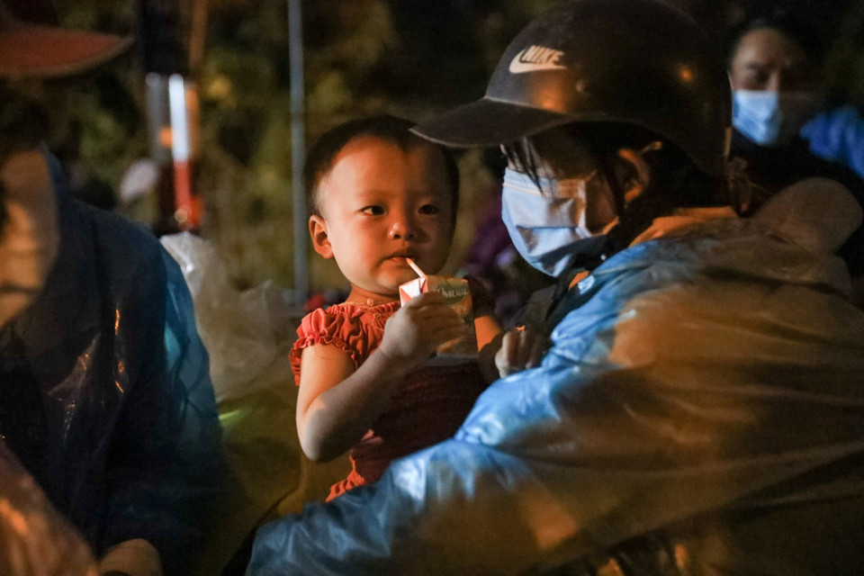 Nhiều hộ dân có con nhỏ gặp rất nhiều khó khăn, vất vả trong quá trình di chuyển. (Ảnh: Thành Đạt/TTXVN)