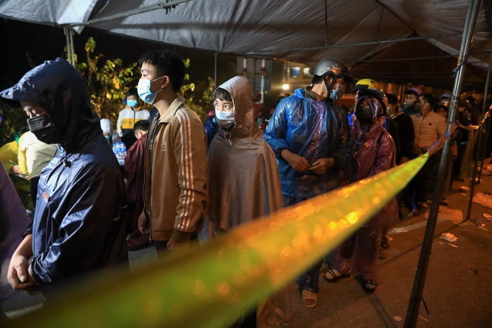 Người dân xếp hàng chờ khai báo y tế tại chốt kiểm soát QL1A rạng sáng 6/10 (Ảnh chụp lúc 4h sáng). (Ảnh: Thành Đạt/TTXVN)