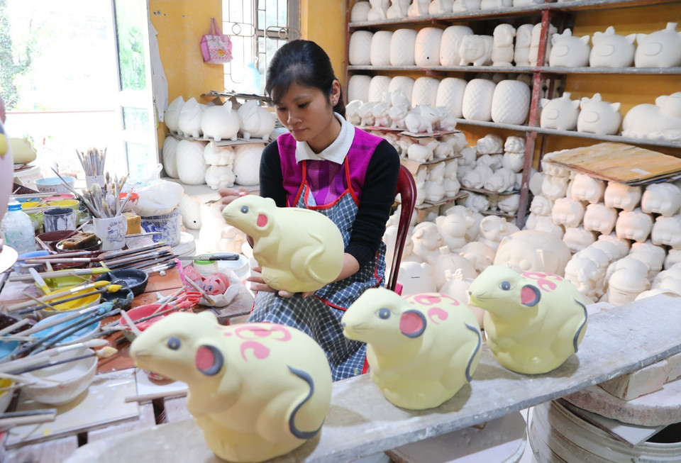 Công đoạn vẽ mẫu chuẩn bị cho lên lò nung sản phẩm gốm Kỳ Linh Canh Tý. (Ảnh: Thành Đạt/TTXVN)