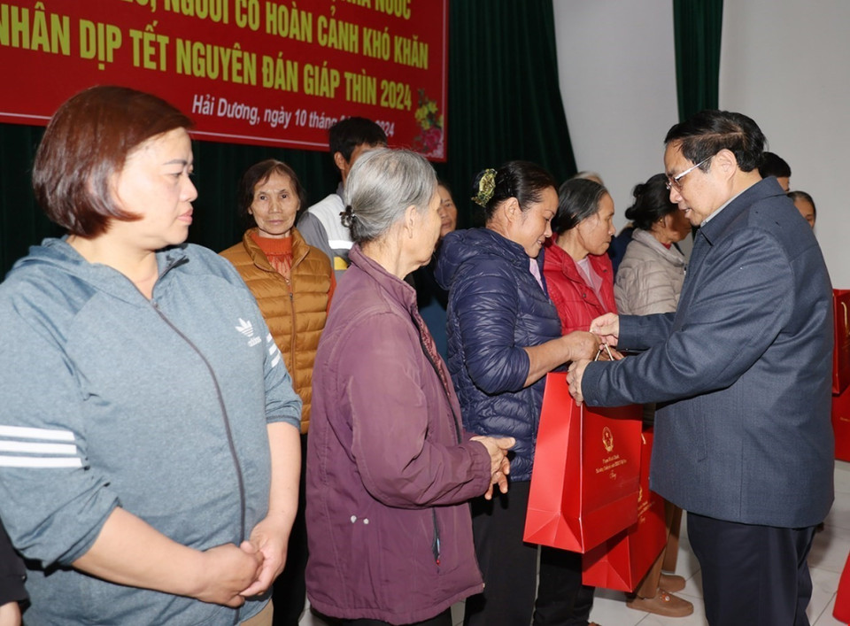 Thủ tướng Phạm Minh Chính tặng quà cho hộ nghèo, người có hoàn cảnh khó khăn thành phố Chí Linh. (Ảnh: Dương Giang/TTXVN)