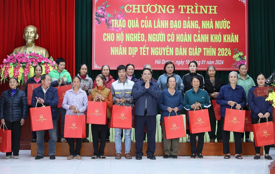 Thủ tướng Phạm Minh Chính tặng quà cho hộ nghèo, người có hoàn cảnh khó khăn thành phố Chí Linh. (Ảnh: Dương Giang/TTXVN)
