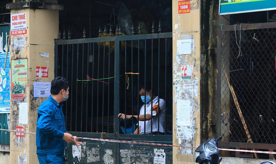 Lực lượng bảo vệ chợ Nhân Chính đóng cửa chợ khi có thông báo của UBND phường Nhân Chính. (Ảnh: Tuấn Anh/TTXVN)