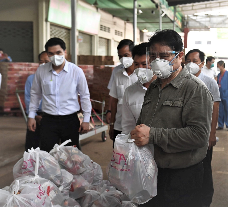 Thủ tướng Chính phủ Phạm Minh Chính, Trưởng Ban chỉ đạo Quốc gia phòng, chống dịch COVID-19 kiểm tra gói an sinh cấp cho người dân trên địa bàn thành phố Thuận An, tỉnh Bình Dương. (Ảnh: TTXVN phát)