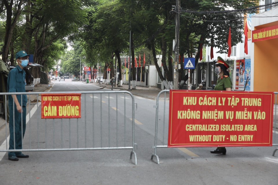 Lực lượng chức năng trực chốt bên ngoài điểm cách ly tập trung tại trường Tiểu học và Trung học cơ sở Phú Thượng (quận Tây Hồ). (Ảnh: Minh Quyết/TTXVN) 