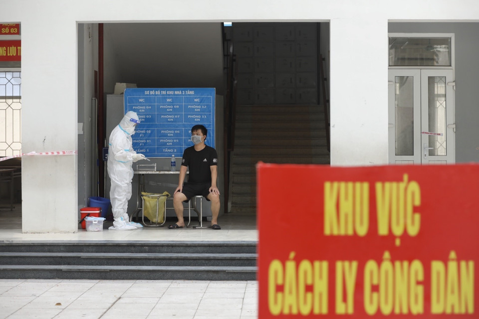 Nhân viên y tế quận Tây Hồ lấy mẫu xét nghiệm COVID-19 cho người thực hiện cách ly. (Ảnh: Minh Quyết/TTXVN) 