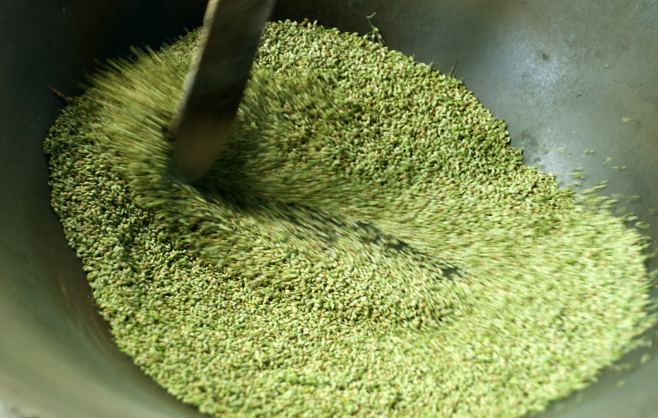 Rang cốm phải đều tay để hạt cốm không bị cháy, không khô, xanh đều. (Ảnh: Quốc Khánh/TTXVN)