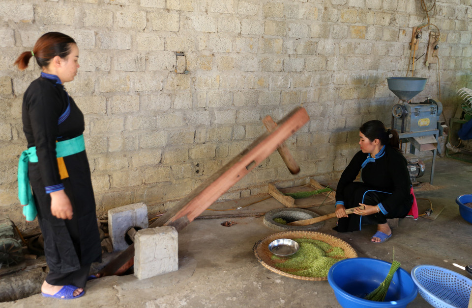 Cốm được giã thủ công bằng cối đá cho hạt cốm dẻo mềm. (Ảnh: Quốc Khánh/TTXVN)