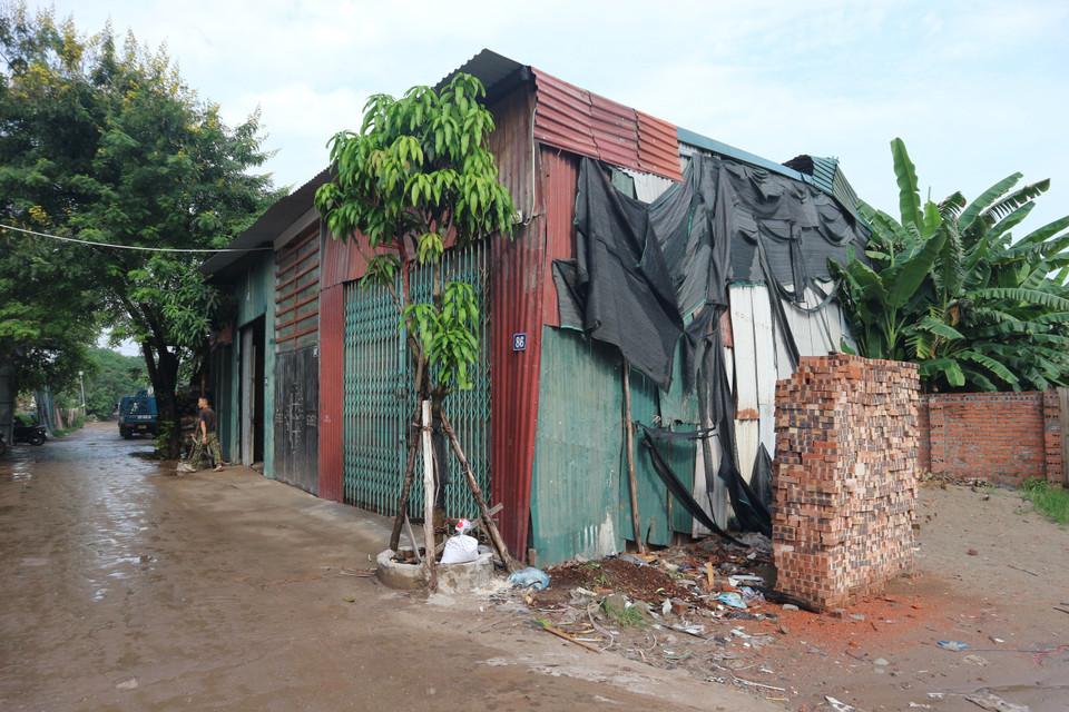 Nhiều chủ nhân đã tập kết vật liệu chờ cơ hội để xây dựng bên trong nhà quây tôn. (Ảnh: Mạnh Khánh/TTXVN)