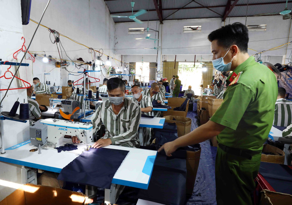 Cán bộ trại giam Ninh Khánh hướng dẫn phạm nhân lao động sản xuất. (Ảnh: Phạm Kiên/TTXVN)